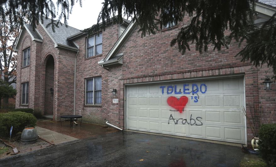 EDS NOTE: VULGAR LANGUAGE BEHIND THE WORK TOLEDO - A heart, painted over a swastika and graffiti cursing Arabs, is pictured on the garage door of the Eltatwy family home in Sylvania Township, Ohio, Thursday, Jan. 12, 2017. Resident Souheir Eltatawy said her daughter painted over the hateful graffiti. Vandals painted the swastika and graffiti on the garage sometime on Tuesday evening, Jan. 10. (Dave Zapotosky/The Blade via AP)