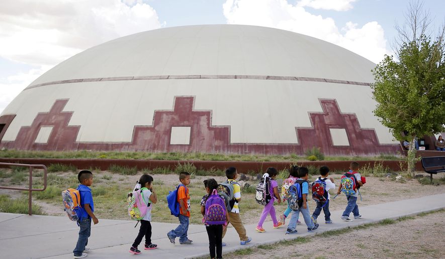 FILE - In this Sept. 25, 2014 file photo, students walk between buildings at the Little Singer Community School in Birdsprings, Ariz., on the Navajo Nation. A federal lawsuit filed Thursday, Jan. 12, 2017, says U.S. Bureau of Indian Education schools are chronically understaffed, lack systems to provide special education and have a deficient curriculum. A coalition of advocacy groups announced the lawsuit involving Havasupai students at a northern Arizona school inside the Grand Canyon, but which could affect other BIE schools. (AP Photo/John Locher, File)