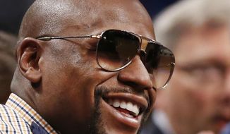 Retired boxer and current boxing promoter Floyd Mayweather smiles during the first half of an NBA basketball game between the Brooklyn Nets and the New Orleans Pelicans, Thursday, Jan. 12, 2017, in New York. (AP Photo/Kathy Willens)
