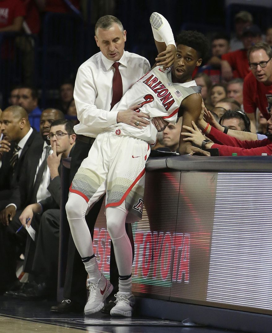 Arizona State head coach Bobby Hurley helps Arizona guard Kobi Simmons (2) from falling during the second half of an NCAA college basketball game, Thursday, Jan. 12, 2017, in Tucson, Ariz. Arizona defeated Arizona State 91-75. (AP Photo/Rick Scuteri)