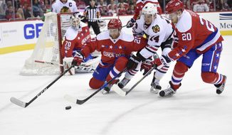 Washington Capitals defenseman Karl Alzner (27) and center Lars Eller (20), of Denmark, chase the puck against Chicago Blackhawks left wing Richard Panik (14), Slovakia, during the second period of an NHL hockey game, Friday, Jan. 13, 2017, in Washington. (AP Photo/Nick Wass)