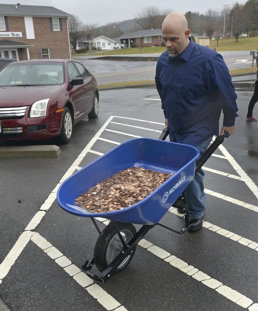 Nick Stafford rolls in 1 of 5 wheelbarrows full of change, mostly pennies, to the DMV in Lebanon, Va., Wednesday, Jan. 11, 2017.  Stafford was paying the sales tax on two cars that he was titling. He had paid $165 to file three lawsuits in Russell County General District Court: two against specific employees at the Lebanon DMV and one against the DMV itself., which means he spent $1,005 to get 10 phone numbers and the satisfaction of delivering 300,000 pennies. Not to mention the nearly $3,000 he paid the DMV for the cars. (David Criggeru/The Bristol Herald-Courier via AP)