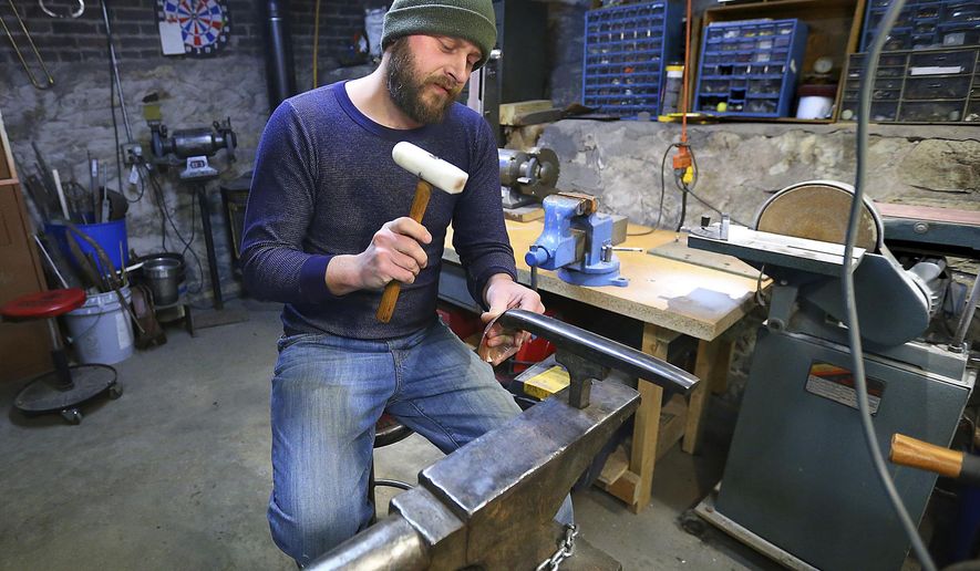 In this Jan. 9, 2017 photo, Adam Oldre works a piece of metal in his shop, in La Crosse, Wis. Oldre creates vessels and jewelry from recycled and repurposed metals. Oldre has been invited to participate in the American Concern for Artistry and Craftsmanship&#x27;s ACAC Annual Craft and Fine Art Festival in New York, a prestigious juried show.  (Erik Daily  /La Crosse Tribune via AP)