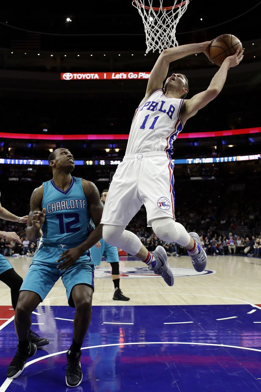 Philadelphia 76ers' Nik Stauskas, right, goes up for a shot against Charlotte Hornets' Treveon Graham during the first half of an NBA basketball game, Friday, Jan. 13, 2017, in Philadelphia. (AP Photo/Matt Slocum)
