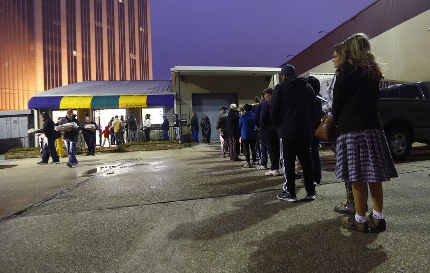Customers wait in line in the early morning hours, to buy king cakes at Manny Randazzo King Cakes, in Metairie, La., a suburb of New Orleans, Friday, Jan. 6, 2017. People in this town take tradition seriously and few traditions are as important as King Cake. For many residents, the type of King Cake you buy isn't as important as when you buy it: Eating King Cake before the Twelfth Night (Jan. 6) is considered sacrilegious. (AP Photo/Gerald Herbert)