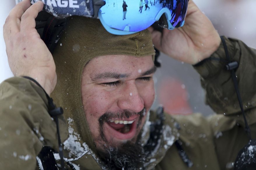 Roman Sena, Marine Corps veteran, finishes a snowboarding run during Team Semper Fi Ski & Snowboard Camp, where veterans and their families can learn to ski with instruction from the National Ability Center, at Park City Mountain Resort in Park City on Wednesday, Jan. 11, 2017. (Kristin Murphy/The Deseret News via AP)