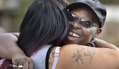 Velma Aiken, the paternal grandmother of Kamiyah Mobley, who was kidnapped as an infant 18 years ago, gets a congratulatory hug from a family member after Mobley was found safe Friday, Jan. 13, 2017, in Jacksonville, Fla.  (Will Dickey /The Florida Times-Union via AP)