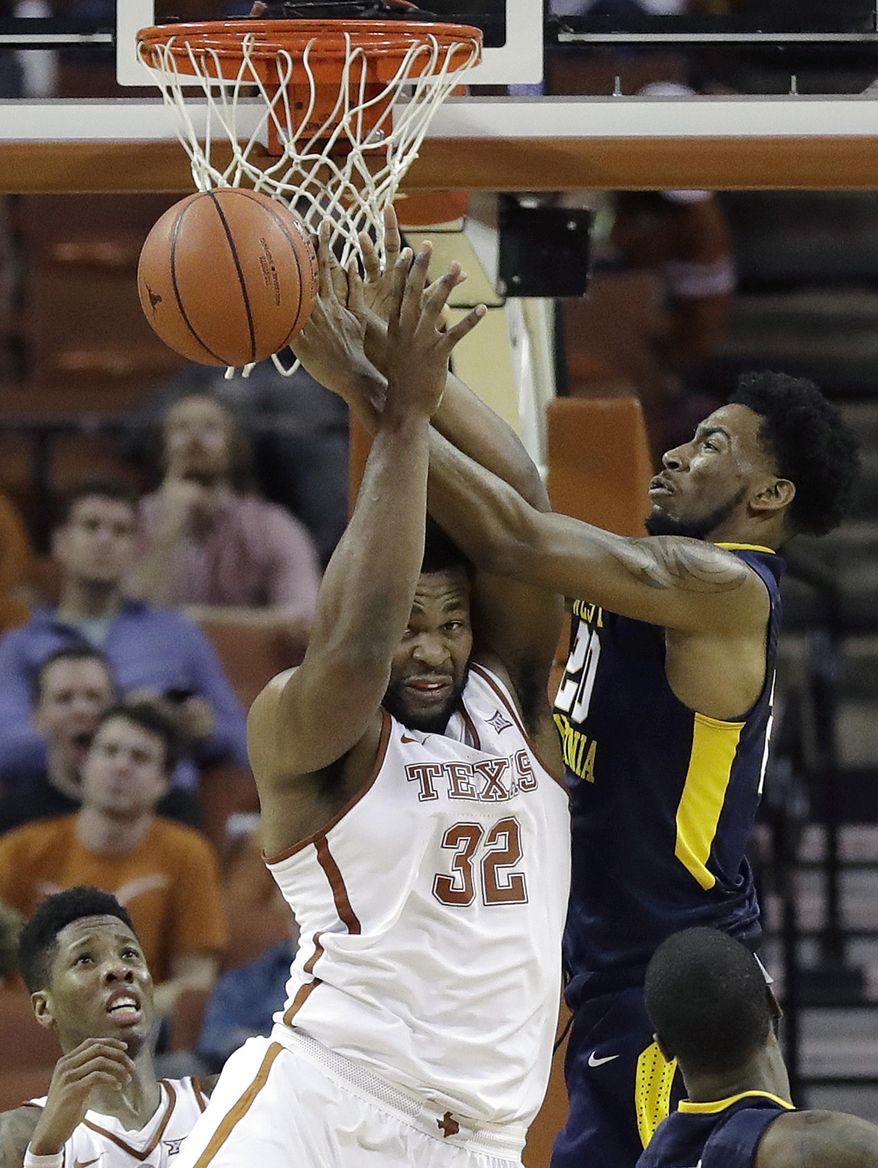 Texas forward Shaquille Cleare (32) and West Virginia forward Brandon Watkins (20) battle for a rebound during the second half of an NCAA college basketball game, Saturday, Jan. 14, 2017, in Austin, Texas. West Virginia won 74-72. (AP Photo/Eric Gay)