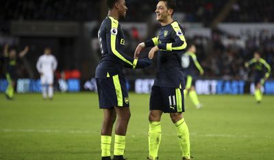 Arsenal&#x27;s Alex Iwobi, right, celebrates after his shot deflected off Swansea City&#x27;s Kyle Naughton (not pictured) for a own goal and Arsenal&#x27;s third of the game during the English Premier League soccer match between Swansea City and Arsenal at the Liberty Stadium, Swansea, Wales, Saturday, Jan. 14, 2017.(Nick Potts/PA via AP)