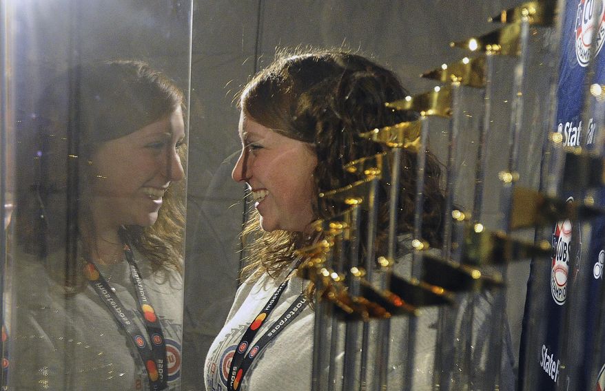Chicago Cubs fan Taryn Nickow, of Buffalo Grove, Ill., has her picture taken with the World Series trophy, at the Cubs Convention in Chicago on Friday, Jan. 13, 2017. (Mark Welsh/Daily Herald via AP)