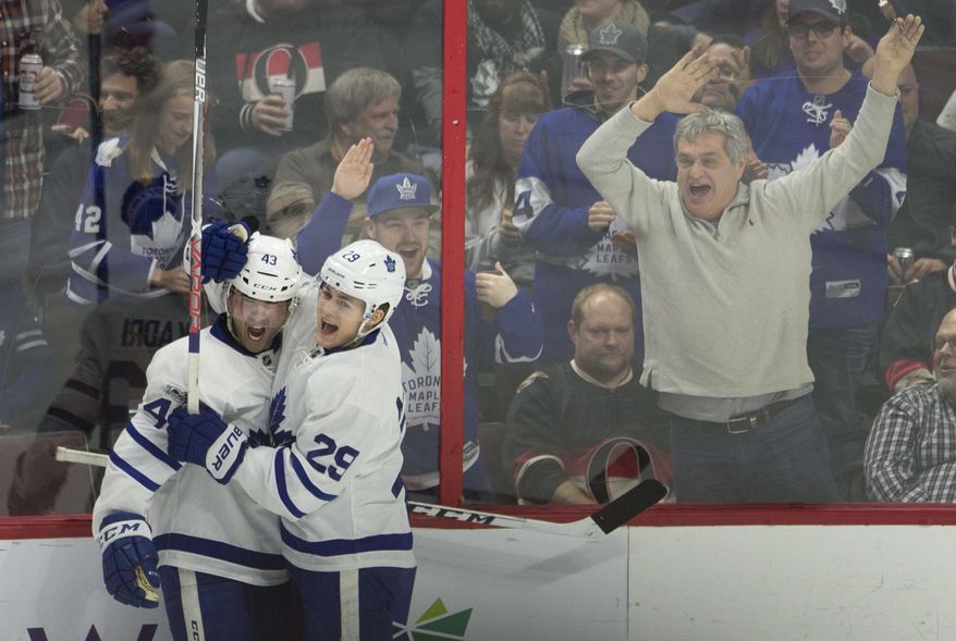 Fans react as Toronto Maple Leafs center Nazem Kadri, left, celebrates his second goal with teammate William Nylander during the third period of an NHL hockey game against the Ottawa Senators, Saturday, Jan. 14, 2017, in Ottawa, Ontario. (Adrian Wyld/The Canadian Press via AP)