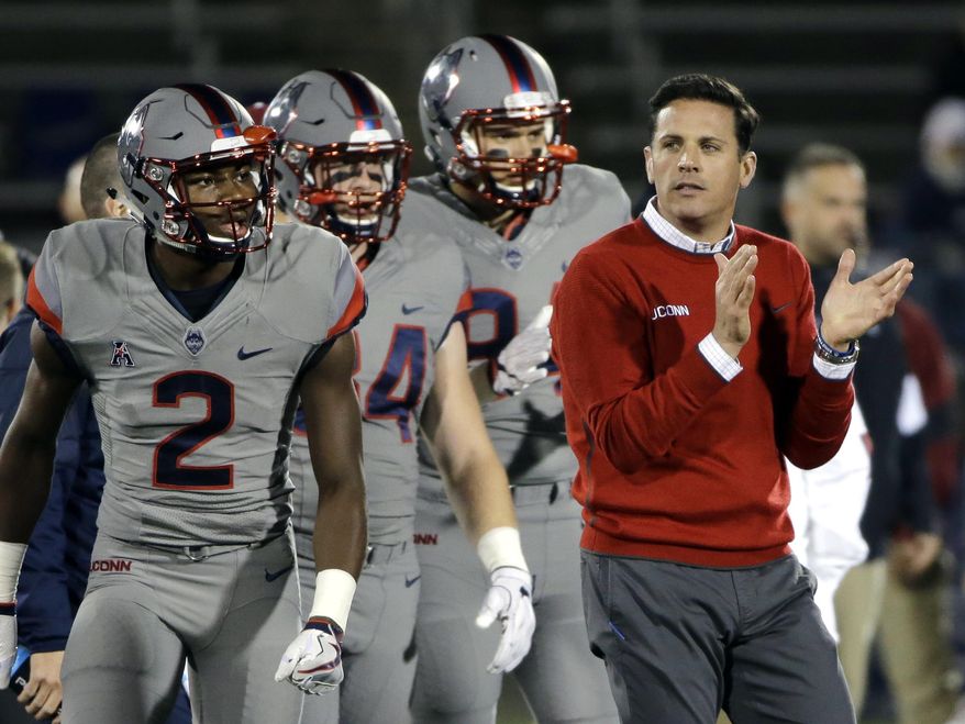 FILE - Int his Nov. 4, 2016, file photo, Connecticut coach Bob Diaco watches his players warm up for an NCAA college football game against Temple in East Hartford, Conn. Former UConn head coach Bob Diaco has been named the new defensive coordinator at Nebraska.  UConn fired Diaco last month after three straight losing seasons. Nebraska coach Mike Riley hired Diaco to take over a Nebraska defense that struggled in the most important games. He replaces Mark Banker, who was fired Wednesday.  (AP Photo/Elise Amendola, File_