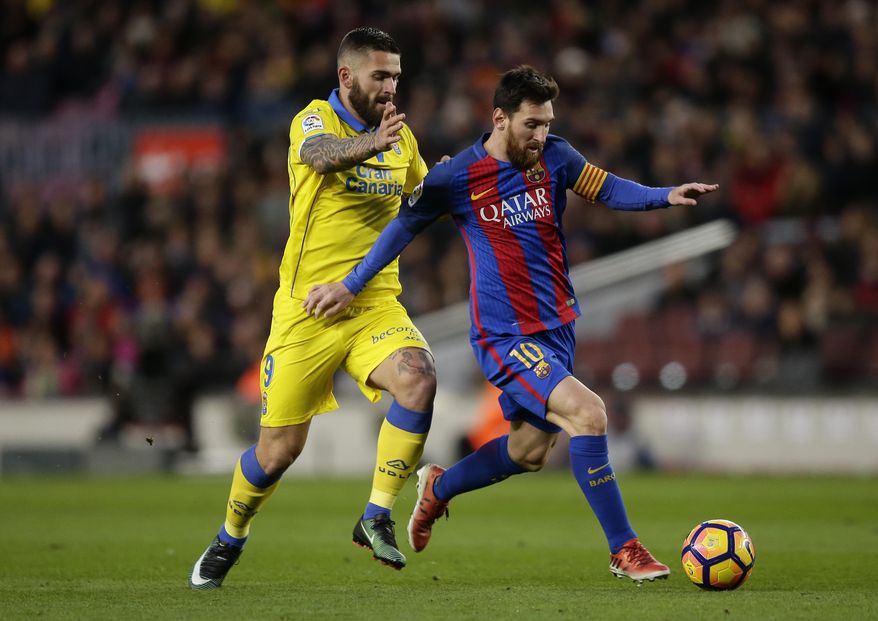 FC Barcelona's Lionel Messi, left, duels for the against Las Palmas' Mauricio Lemos during the Spanish La Liga soccer match between FC Barcelona and Las Palmas at the Camp Nou in Barcelona, Spain, Saturday, Jan. 14, 2017. (AP Photo/Manu Fernandez)