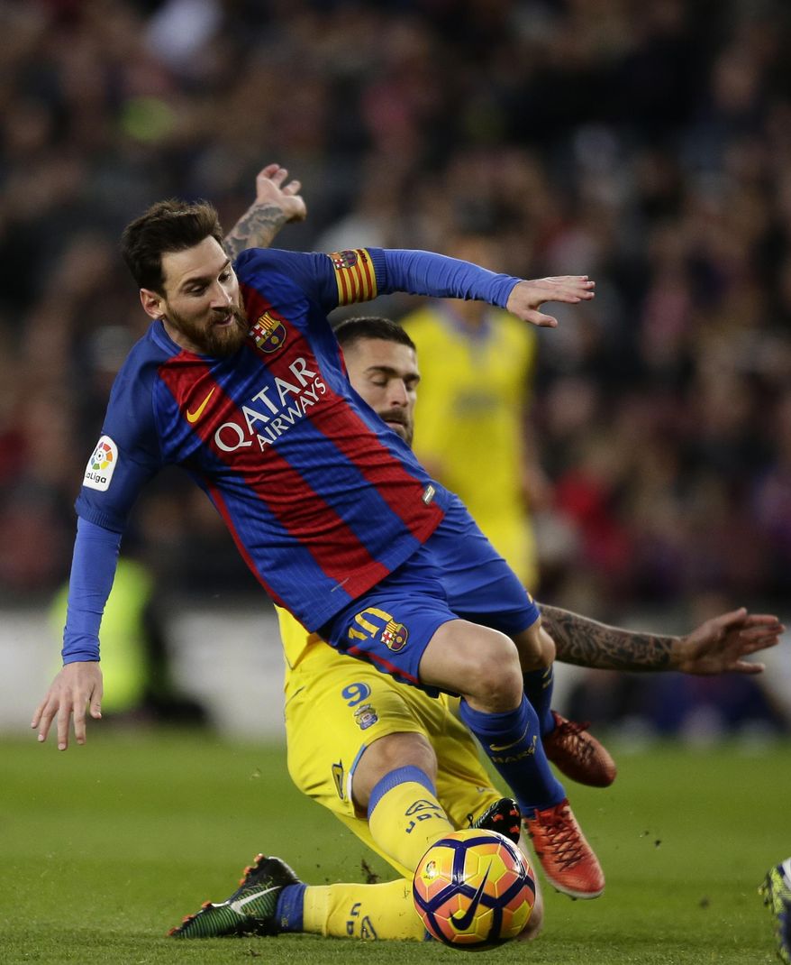 FC Barcelona's Lionel Messi, front, duels for the ball against Las Palmas' Mauricio Lemos during the Spanish La Liga soccer match between FC Barcelona and Las Palmas at the Camp Nou in Barcelona, Spain, Saturday, Jan. 14, 2017. (AP Photo/Manu Fernandez)