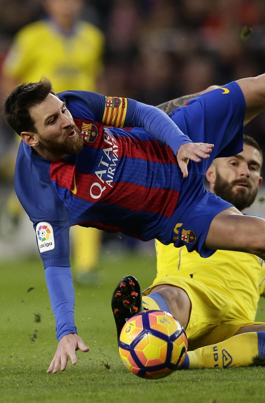 FC Barcelona's Lionel Messi, left, falls during the Spanish La Liga soccer match between FC Barcelona and Las Palmas at the Camp Nou in Barcelona, Spain, Saturday, Jan. 14, 2017. (AP Photo/Manu Fernandez)