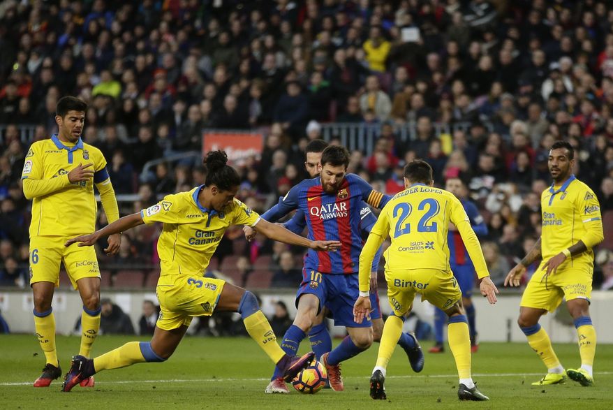 FC Barcelona's Lionel Messi, center, runs with the ball during the Spanish La Liga soccer match between FC Barcelona and Las Palmas at the Camp Nou in Barcelona, Spain, Saturday, Jan. 14, 2017. (AP Photo/Manu Fernandez)