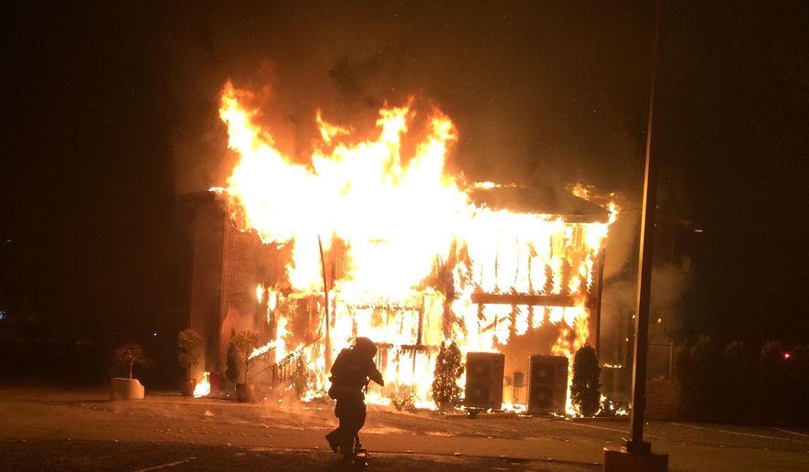 This photo provided by Bellevue, Wash., Fire Department, a fire burns at the Islamic Center of the Eastside in Bellevue, Wash., on Saturday, Jan. 14, 2017. Police say a man is in custody after a suspicious fire severely damaged the mosque overnight. Authorities say that as firefighters doused the flames, police found a 37-year-old man near the building and arrested him for investigation of arson. Police spokesman Seth Tyler says investigators believe the man is the sole suspect. His name was not immediately released. The mosque was unoccupied at the time and no injuries were reported. (Bellevue, Wash., Fire Department via AP)