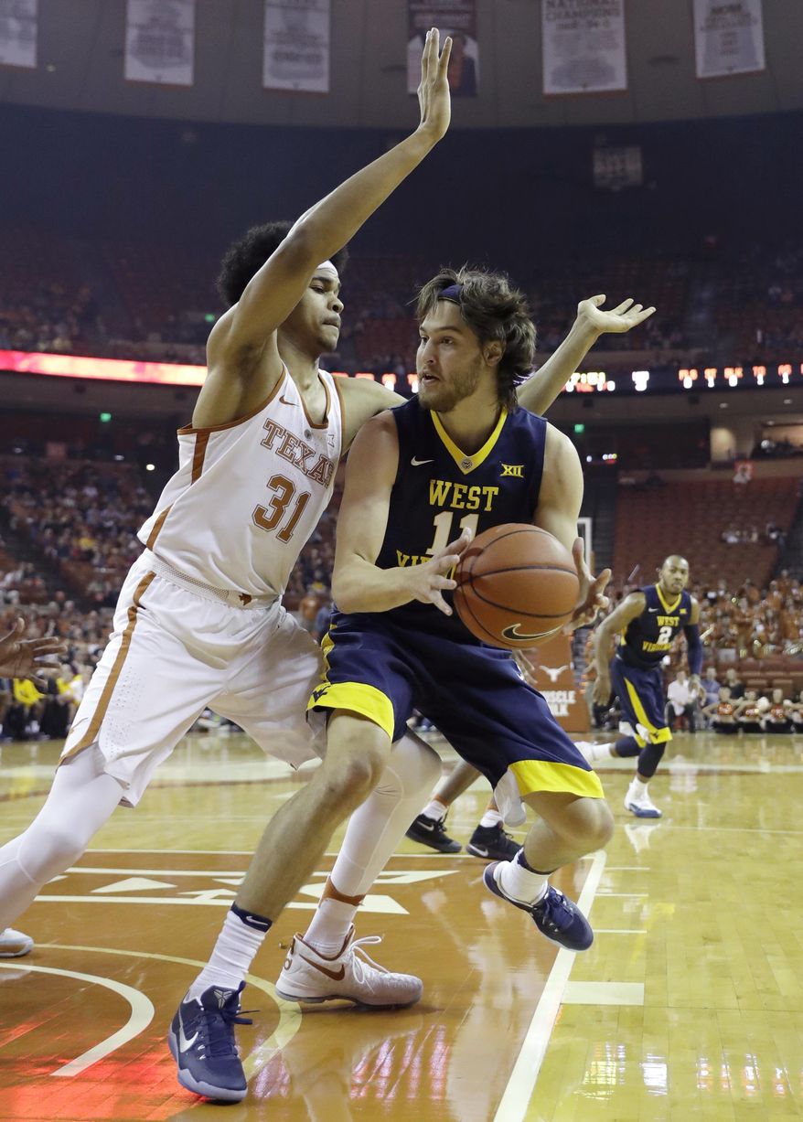 West Virginia forward Nathan Adrian (11) is pressured by Texas forward Jarrett Allen (31) during the first half of an NCAA college basketball game, Saturday, Jan. 14, 2017, in Austin, Texas. (AP Photo/Eric Gay)