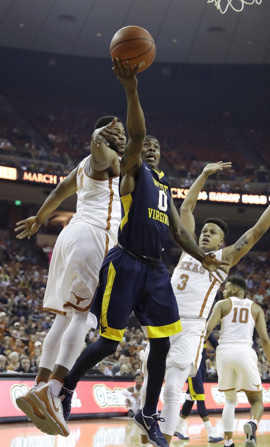 West Virginia guard Teyvon Myers (0) shoots past Texas forward Shaquille Cleare (32) during the first half of an NCAA college basketball game, Saturday, Jan. 14, 2017, in Austin, Texas. (AP Photo/Eric Gay)