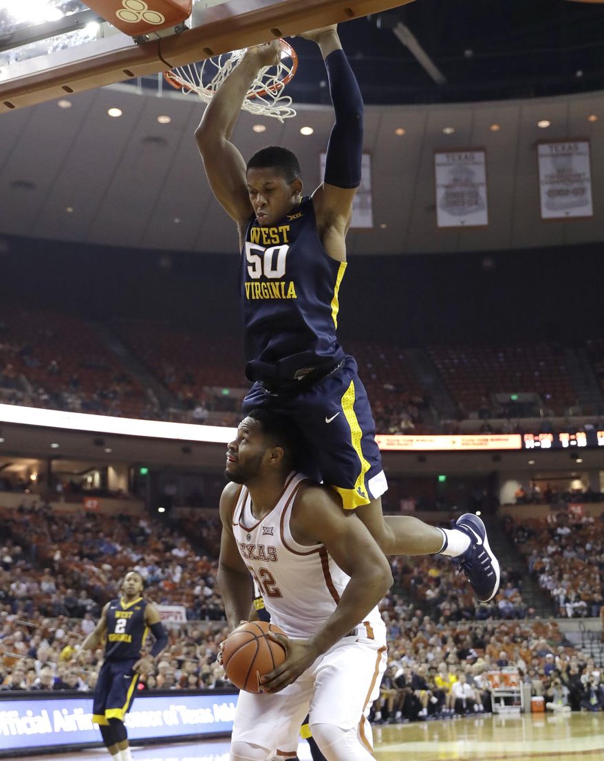 Texas forward Shaquille Cleare (32) looks to shoot as West Virginia forward Sagaba Konate (50) hangs over him during the second half of an NCAA college basketball game, Saturday, Jan. 14, 2017, in Austin, Texas. West Virginia won 74-72. (AP Photo/Eric Gay)