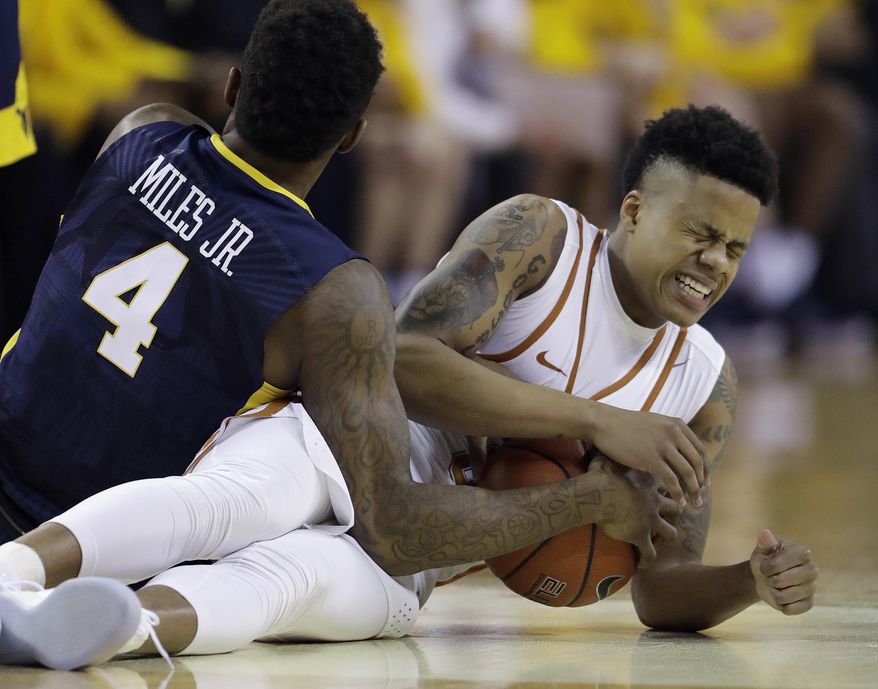 West Virginia guard Daxter Miles Jr. (4) and Texas guard Jacob Young (3) scramble for a loose ball during the first half of an NCAA college basketball game, Saturday, Jan. 14, 2017, in Austin, Texas. (AP Photo/Eric Gay)