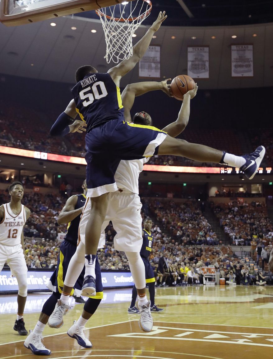 West Virginia forward Sagaba Konate (50) blocks a shot by Texas forward Shaquille Cleare (32) during the second half of an NCAA college basketball game, Saturday, Jan. 14, 2017, in Austin, Texas. West Virginia won 74-72. (AP Photo/Eric Gay)