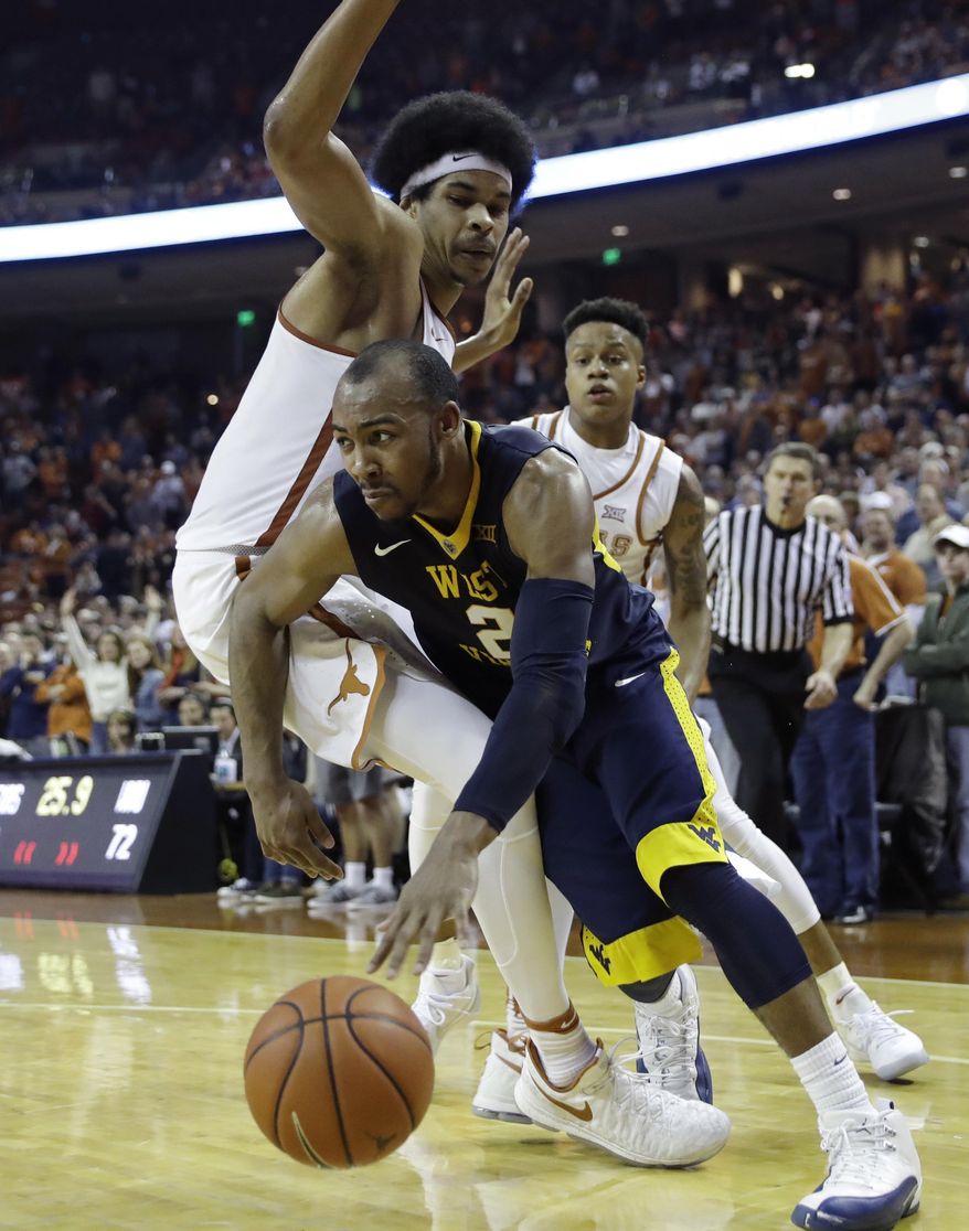 West Virginia guard Jevon Carter (2) drives the ball around Texas forward Jarrett Allen (31) during the second half of an NCAA college basketball game, Saturday, Jan. 14, 2017, in Austin, Texas. West Virginia won 74-72. (AP Photo/Eric Gay)