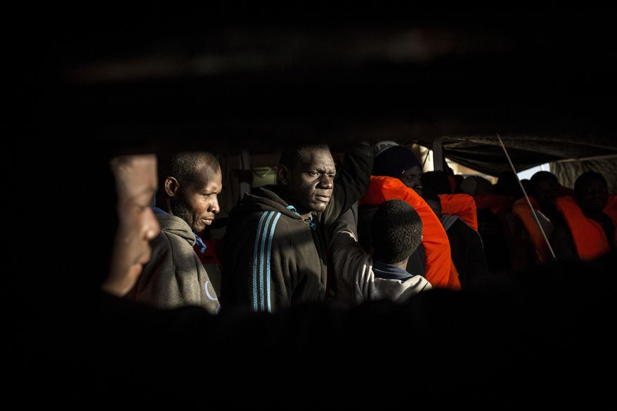 In this Friday Jan. 13, 2017 photo, men from Mali stand on the deck of the Golfo Azzurro vessel after being rescued from the Mediterranean sea, about 20 miles north of Ra's Tajura, Libya. Spain's maritime rescue service says the bodies of seven African migrants have been found dead along the Strait of Gibraltar since Friday. (AP Photo/Olmo Calvo)