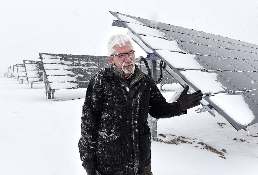 In this Tuesday, Jan. 10, 2017 photo, Tom Kroll, director of the Saint John's University Arboretum in Collegeville, Minn., describes the power output of the new solar panels at the university's solar farm. With the newest expansion, the farm now covers 23 acres and can power about 525 homes. (Jason Wachter/St. Cloud Times via AP)