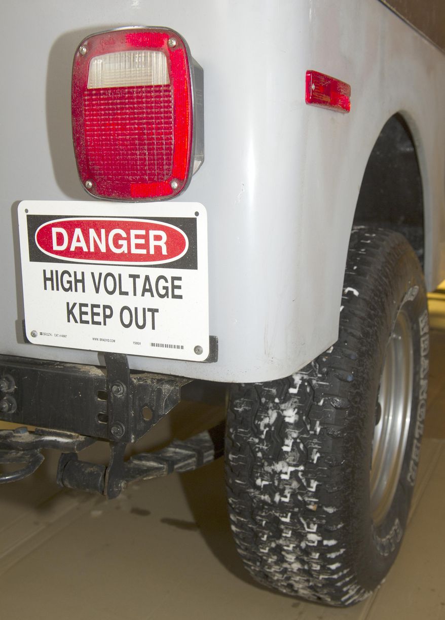 In a Jan. 5, 2017 photo, a high voltage sign is the only giveaway that all is not as expected under the hood of the electric-powered CJ-7 Jeep Adam Verhage built with his father Carroll. (Eric Gregory/The Journal-Star via AP)