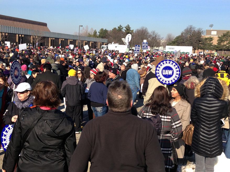 People wait for the start of a health care rally in Warren, Mich., north of Detroit, Sunday, Jan. 15, 2017. Thousands of people endured freezing temperatures at the rally in Warren, where Sen. Bernie Sanders called on Americans to resist Republican efforts to repeal President Barack Obama’s health care law. The rally was one of a number of rallies Democrats staged across the country to highlight opposition to the repeal efforts. (AP Photo/Corey R. Williams)