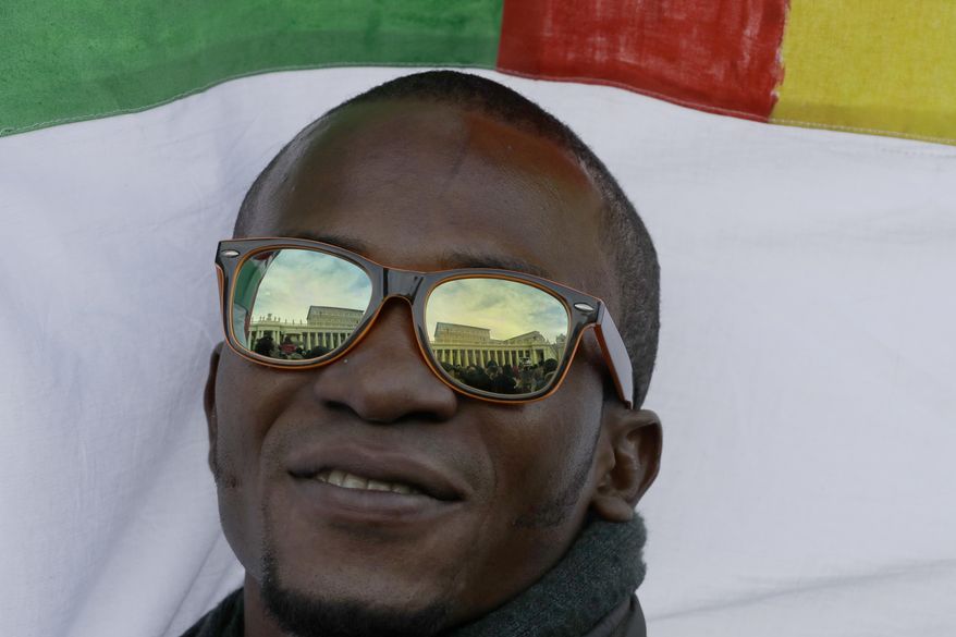 The Apostolic palace is reflected on the glasses of a migrant attending the Angelus noon prayer delivered by Pope Francis in St. Peter's Square at the Vatican, Sunday, Jan.15, 2017. (AP Photo/Andrew Medichini)