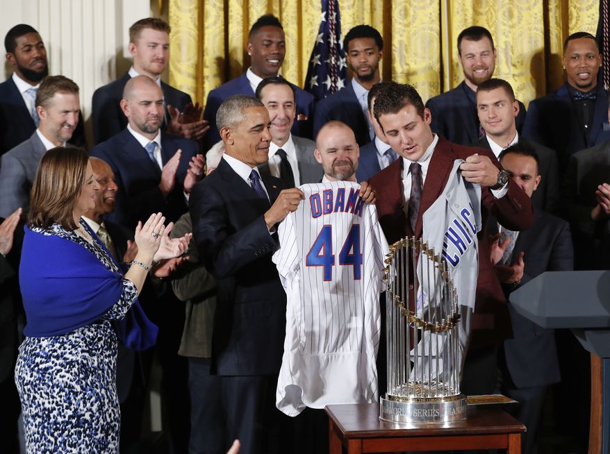 President Barack Obama holds up a personalized Chicago Cubs baseball jersey presented to him by Anthony Rizzo, right, during a ceremony in the East Room of the White House in Washington, Monday, Jan. 16, 2017, where the president honored the 2016 World Series Champion baseball team. (AP Photo/Pablo Martinez Monsivais)