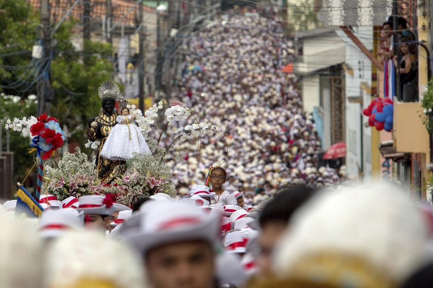 This Dec. 26, 2016 photo shows a procession in honor of St. Benedict filling a street in the fishing town of Braganca, Brazil during Marujada religious celebrations. Started in 1798, the event mixes indigenous, African and Portuguese traditions. (AP Photo/Eraldo Peres)
