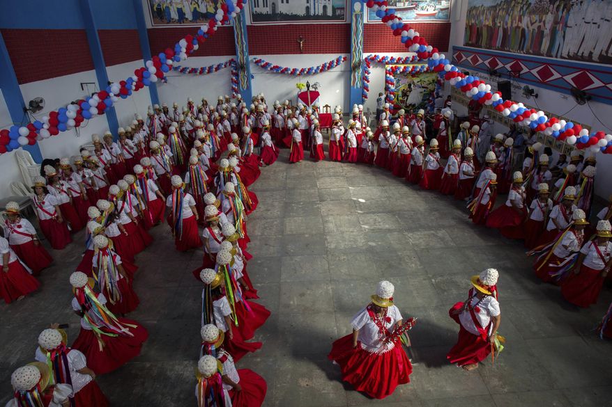 This Dec. 26, 2016 photo shows women performing the Retumbao dance during Marujada religious celebrations in honor of St. Benedict in the fishing town of Braganca, Brazil. Locals say the annual celebration, which started in 1798, is a way to show appreciation and make good on promises for miracles received. (AP Photo/Eraldo Peres)