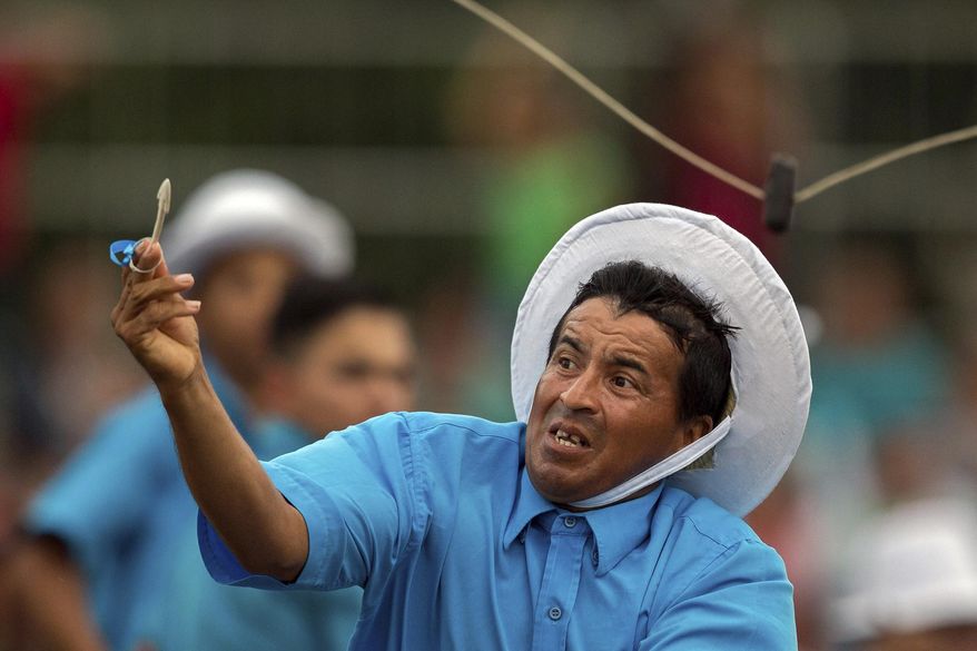 This Dec. 25, 2016 photo shows a cowboy who successfully placed a stick through a small ring during the Cavalhada event, part of Marujada religious celebrations in honor of St. Benedict in the fishing town of Braganca, Brazil. Started in 1798, the "Marujada" religious celebration mixes indigenous, African and Portuguese traditions. (AP Photo/Eraldo Peres)
