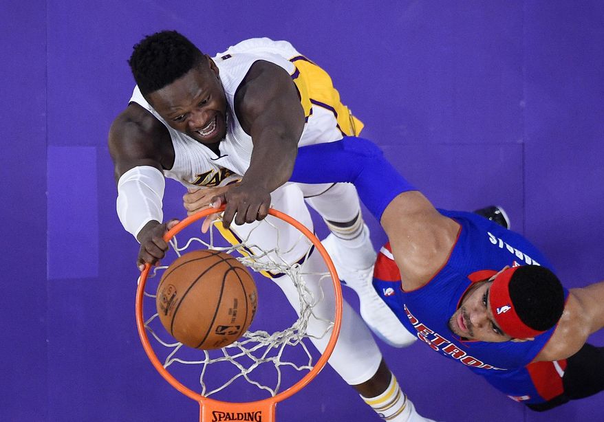 Los Angeles Lakers forward Julius Randle, left, dunks as Detroit Pistons forward Tobias Harris defends during the first half of an NBA basketball game, Sunday, Jan. 15, 2017, in Los Angeles. (AP Photo/Mark J. Terrill)