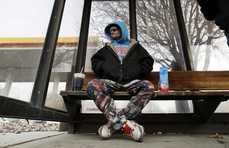 ADVANCE FOR USE TUESDAY, JAN. 17, 2017 AND THEREAFTER-Rodney Rodwell waits to catch a bus in 11-degree weather in Lincoln, Neb., on Wednesday, Jan. 4, 2017. Rodwell, who works odd jobs while on disability and lost his car in 2016, says he wants Donald Trump to keep his campaign promise to stop illegal immigration, which he blames for keeping his pay down. He also hopes Trump legalizes medical marijuana nationally. (AP Photo/Charlie Neibergall)