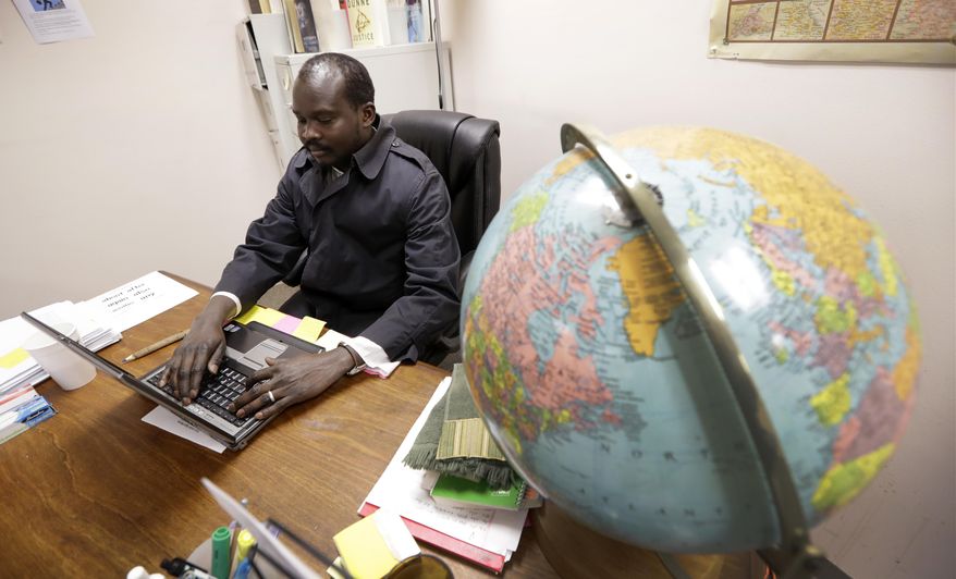 ADVANCE FOR USE TUESDAY, JAN. 17, 2017 AND THEREAFTER-Sudanese refugee Suliman Bandas, who teaches English as second language, works in his classroom in Lincoln, Neb., on Wednesday, Jan. 4, 2017. Bandas says he hopes President-elect Donald Trump won't change the United State's role as a beacon for refugees across the world. “It should not be up to a president to change a country’s value and principle,” he says. (AP Photo/Charlie Neibergall)