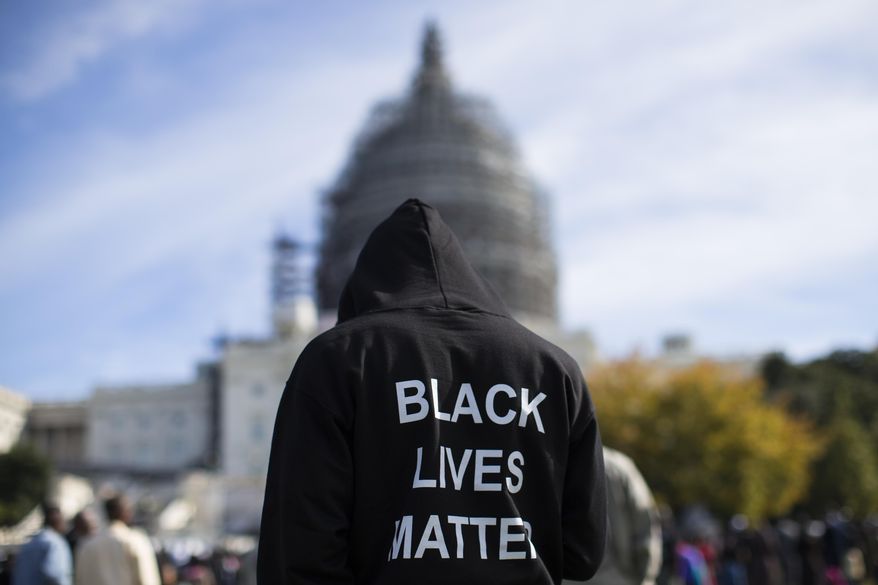 A man wears a hoodie that reads, &quot;Black Lives Matter&quot; as he stands on the lawn of the Capitol building on Capitol Hill in Washington during a rally to mark the 20th anniversary of the Million Man March, Oct. 10, 2015. (AP Photo/Evan Vucci) ** FILE **