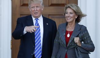 FILE - In this Nov. 19, 2016 file photo, President-elect Donald Trump stands with Education Secretary-designate Betsy DeVos in Bedminster, N.J.  DeVos has spent over two decades advocating for school choice programs, which give students and parents an alternative to traditional public school education. Her confirmation hearing was scheduled for Jan. 17. (AP Photo/Carolyn Kaster, File)