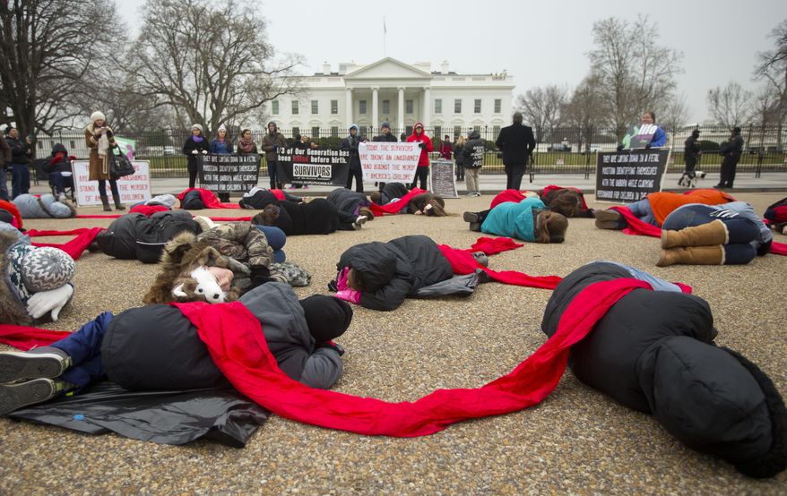 FILE - In a Wednesday, Jan. 21, 2015, file photo, anti-abortion rights activists are connected with a red piece of cloth as they stage a 'die-in' in front of the White House in Washington. Even as the 2016 election outcome intensifies America's abortion debate, a comprehensive new survey released Tuesday, Jan. 17, 2017 by the Guttmacher Institute finds the annual number of abortions in the U.S has dropped to well under 1 million, the lowest level since 1974. (AP Photo/Pablo Martinez Monsivais, File)