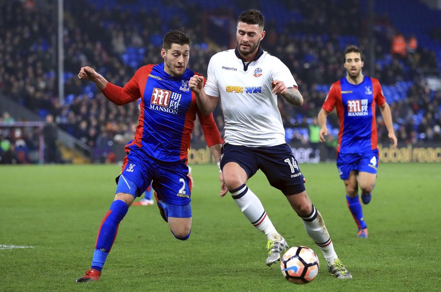 Crystal Palace's Joel Ward, left, and Bolton Wanderers' Gary Madine battle for the ball during the English FA Cup, third round replay match at Selhurst Park, London, Tuesday Jan. 17, 2017. (Tim Goode/PA via AP)