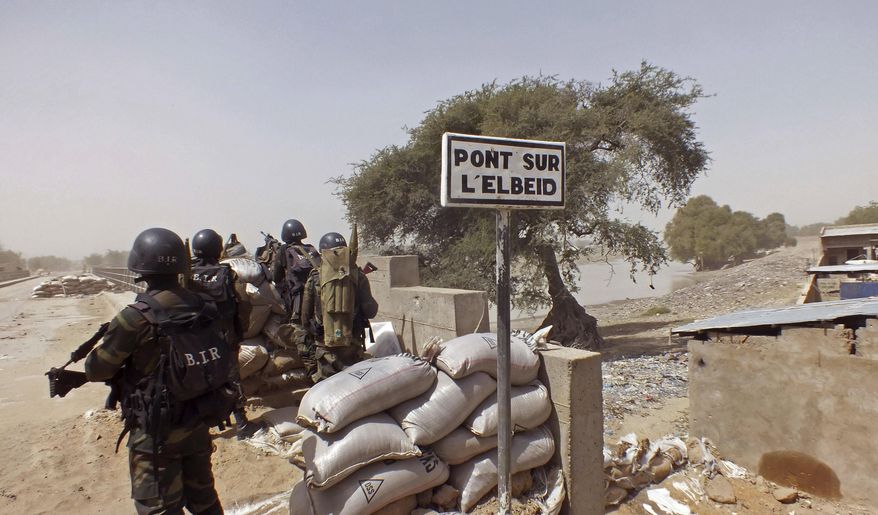 FILE - In this Wednesday, Feb. 25, 2015, file photo, Cameroon soldiers stand guard at a lookout post as they take part in operations against the Islamic extremists group Boko Haram, their guard post is on Elbeid bridge, left rear, that separates northern Cameroon form Nigeria's Borno state near the village of Fotokol, Cameroon. Nigerian Air Force fighter jet on a mission against Boko Haram extremists mistakenly bombed a refugee camp Tuesday, Jan. 27, 2017, killing more than 100 refugees and wounding aid workers, a Borno state government official said. (AP Photo/Edwin Kindzeka Moki, File)