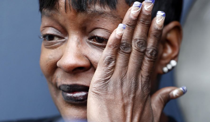 A woman, identified as a neighbor who used to babysit a victim in a shooting that left three people dead, wipes tears as she talks to reporters, Tuesday, Jan. 17, 2017, in Jersey City, N.J. A person familiar with the investigation said police are trying to determine if the shooting was drug related. The person spoke to The Associated Press on condition of anonymity because they weren't authorized to release information about the incident. The gunfire erupted at a home on Fulton Avenue around 10 p.m. Monday. (AP Photo/Julio Cortez)