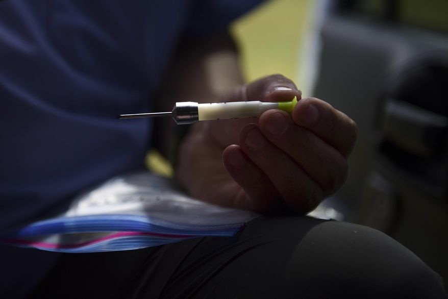 In this Jan. 13, 2017 photo, Dave Pauli, senior director for the U.S. Humane Society wildlife response team, shows the vaccine dart used on horses as part of a birth control program to manage the horse population in Vieques, Puerto Rico. Puerto Rico's tiny Vieques island is famed for its scenery and its free-roaming horses. But there are now so many that officials have joined the Humane Society in a campaign to hold down the population with a campaign of contraceptive darts. (AP Photo/Carlos Giusti)