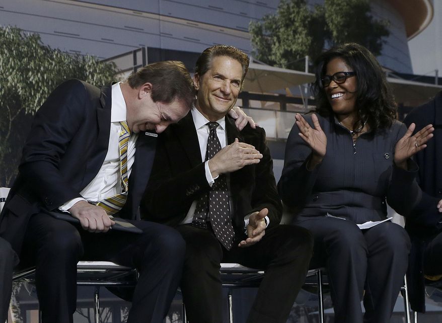 Golden State Warriors owner & CEO Joe Lacob, left, laughs as he leans on the shoulder of co-owner Peter Guber, center, as Chase consumer banking CEO Thasunda Duckett watches during a ground breaking ceremony for the Chase Center in San Francisco, Tuesday, Jan. 17, 2017. (AP Photo/Jeff Chiu)