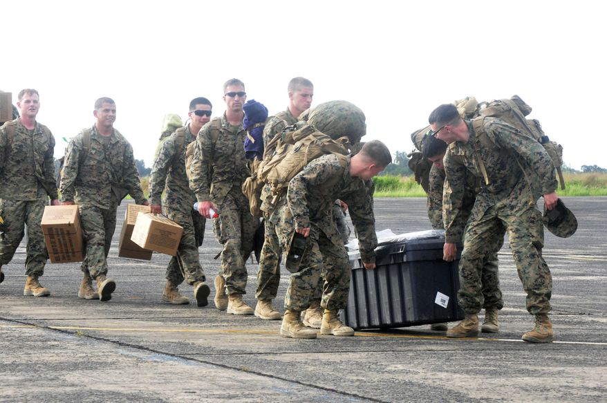 FILE - In this Thursday, Oct. 9, 2014 file photo, U.S marines arrive at the Roberts International airport in Monrovia, Liberia, tasked with helping to fight the Ebola outbreak. Africa was electrified by the rise of Barack Obama, the first U.S. president of African descent, who took aim at the twin scourges of corruption and dictatorship and sent thousands of troops to fight one of the most terrifying disease outbreaks in decades. (AP Photo/Abbas Dulleh, File)