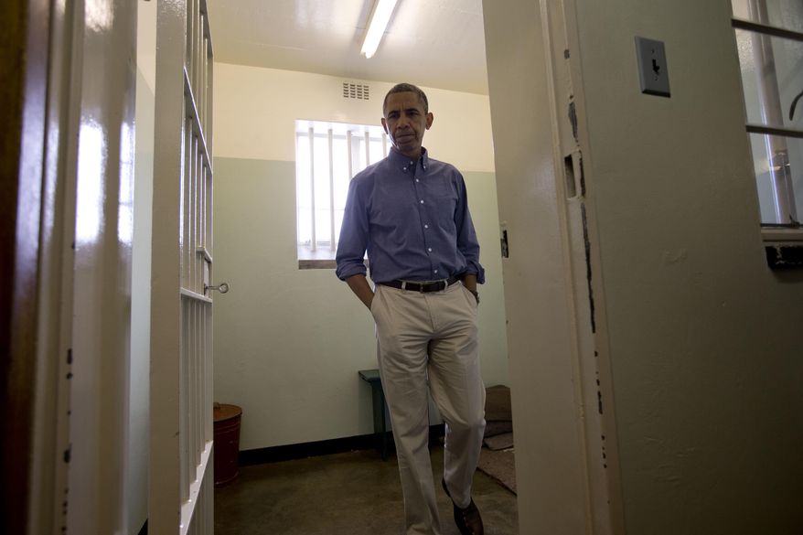 FILE - In this Sunday, June 30, 2013 file photo, U.S. President Barack Obama walks from Section B, prison cell No. 5, where former South African president Nelson Mandela spent 18 years of his 27-year prison term locked up by the former apartheid government, on Robben Island, South Africa. Africa was electrified by the rise of Barack Obama, the first U.S. president of African descent, who took aim at the twin scourges of corruption and dictatorship and sent thousands of troops to fight one of the most terrifying disease outbreaks in decades. (AP Photo/Carolyn Kaster, File)