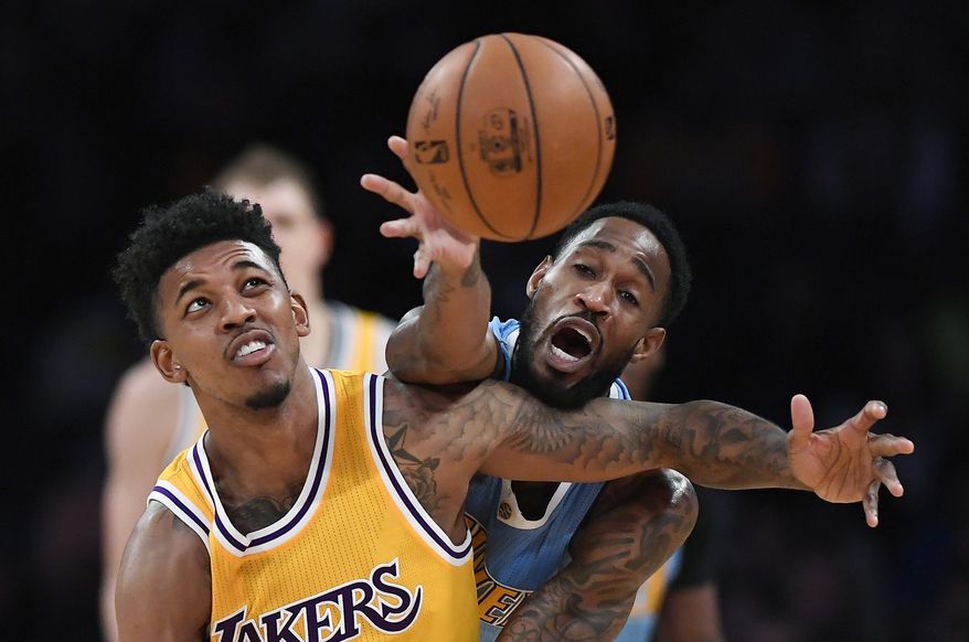 Los Angeles Lakers guard Nick Young, left, and Denver Nuggets guard Will Barton reach for the ball during the first half of an NBA basketball game, Tuesday, Jan. 17, 2017, in Los Angeles. (AP Photo/Mark J. Terrill)